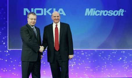Изпълнителните директори на Nokia Стийвън Елоп (в ляво) и на Microsoft Стийв Балмър (в дясно) си стискат ръцете по време на обявяването в Лондон на сътрудничеството между двете компании.
