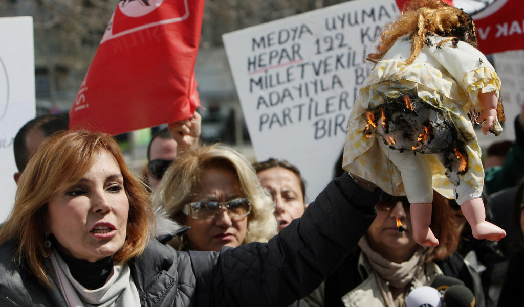 Турската журналистка и активистка за човешки права Рухат Менги държи запалена кукла на протест пред парламента в Анкара срещу изнасилванията и убийствата на жени в Турция на 14 април 2011 г. Демонстрантите обвиниха държавата, че не защитава жените и децата от насилие.