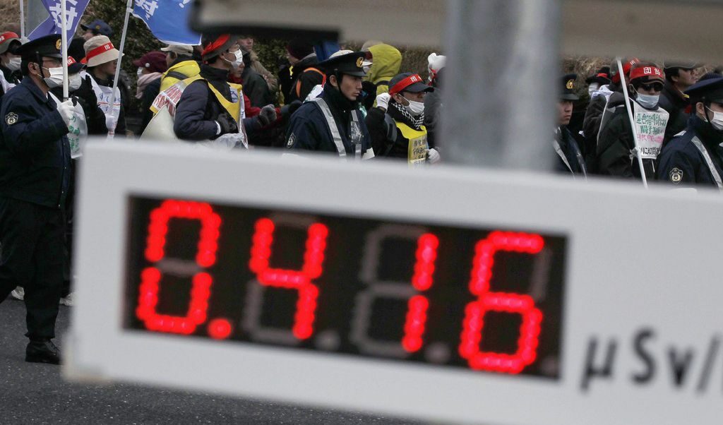 Демонстранти протестират срещу ядрената енергетика в Корияма. На преден план се вижда брояч, отчитащ ниво на радиация от 0,416 микросиверта на час.
