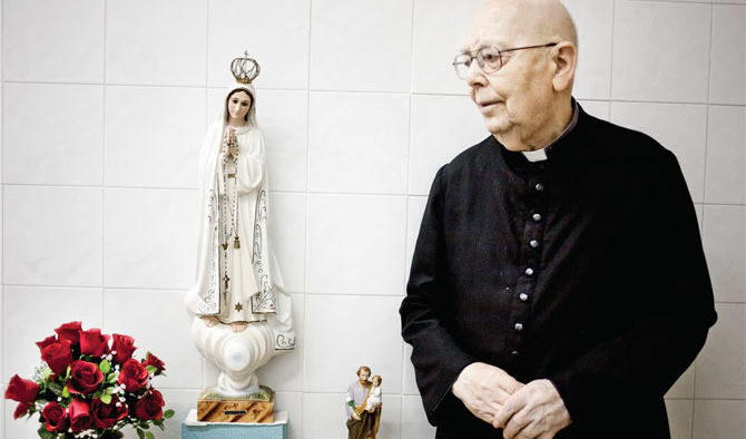 Дон Габриеле Аморт до статуя на Дева Мария, фигура, която той изучава през първите години на духовническия си живот. Дон Аморт е също така главен редактор на Madre di Dio, месечно списание за Дева Мария.