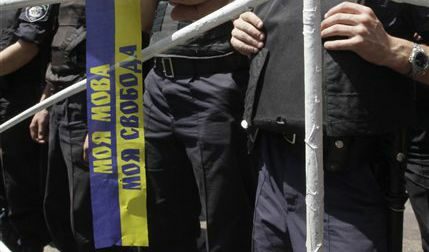 Протестиращ държи шал с надпис "Моят език, моята свобода"