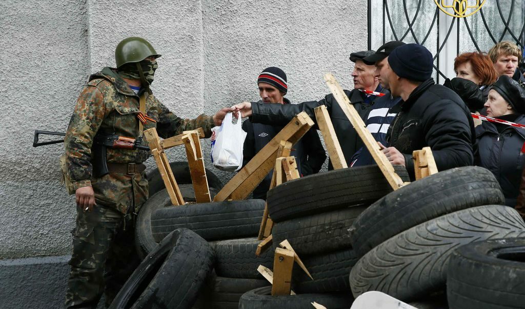 Проруски демонстранти подават провизии на въоръжен мъж в районното управление на Славянск