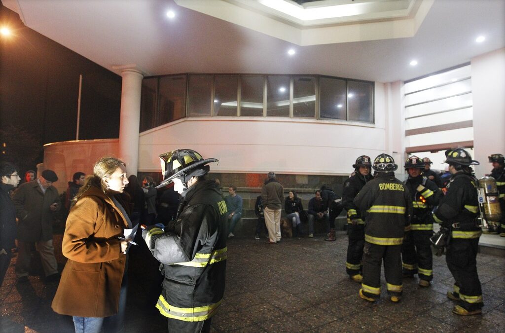 Пожарникари успокояват жителите на блок в Сантяго, Чили, при земетресение, станало вчера