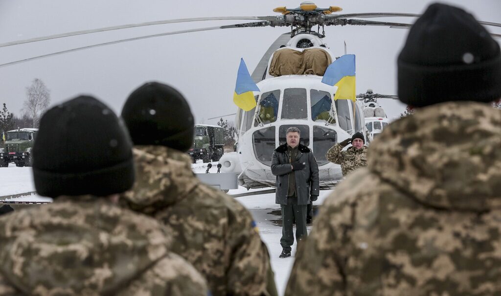 Президентът Порошенко слуша националния химн при посещение преди Нова година на базата Яворив край Лвов в Западна Украйна.