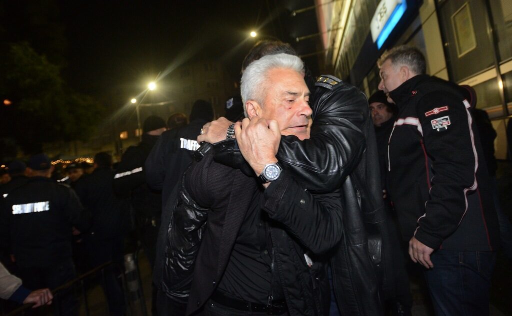 Полицай държи Волен Сидеров. Под дясното око на депутата се вижда раната след удара с юмрук, който му беше нанесен.