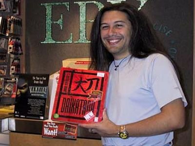 Джон Ромеро позира с копие на Daikatana.