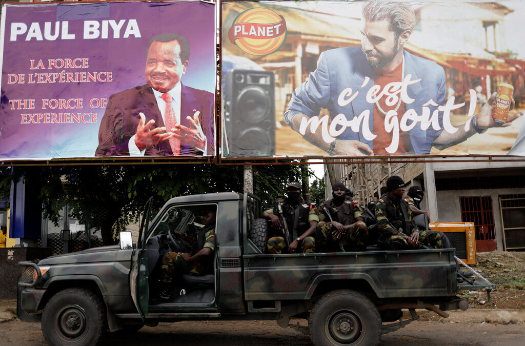 Cameroonian elite Rapid Intervention Battalion (BIR) members sit on their military vehicle under a plazard (L) of Cameroon President Paul Biya, who is running for re-election scheduled for October 7, during a patrol in the south west city of Buea, Cameroon October 4, 2018. Picture taken October 4, 2018.REUTERS/Zohra Bensemra