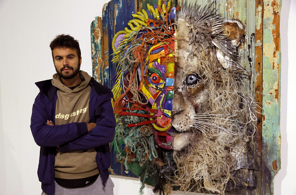Артур Бордал, чийто артистичен псевдоним е Bordalo II, позира до едно от произведенията, представени на изложбата