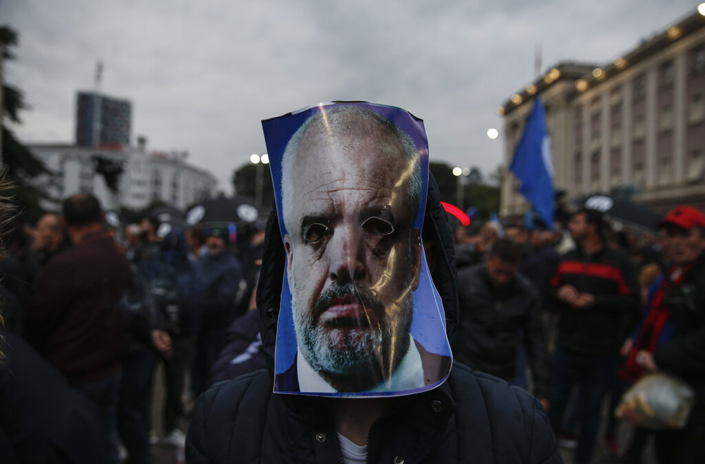 Демонстрант носи маска с лицето на албанския премиер Еди Рама. Демонстрант носи маска с лицето на албанския премиер Еди Рама.