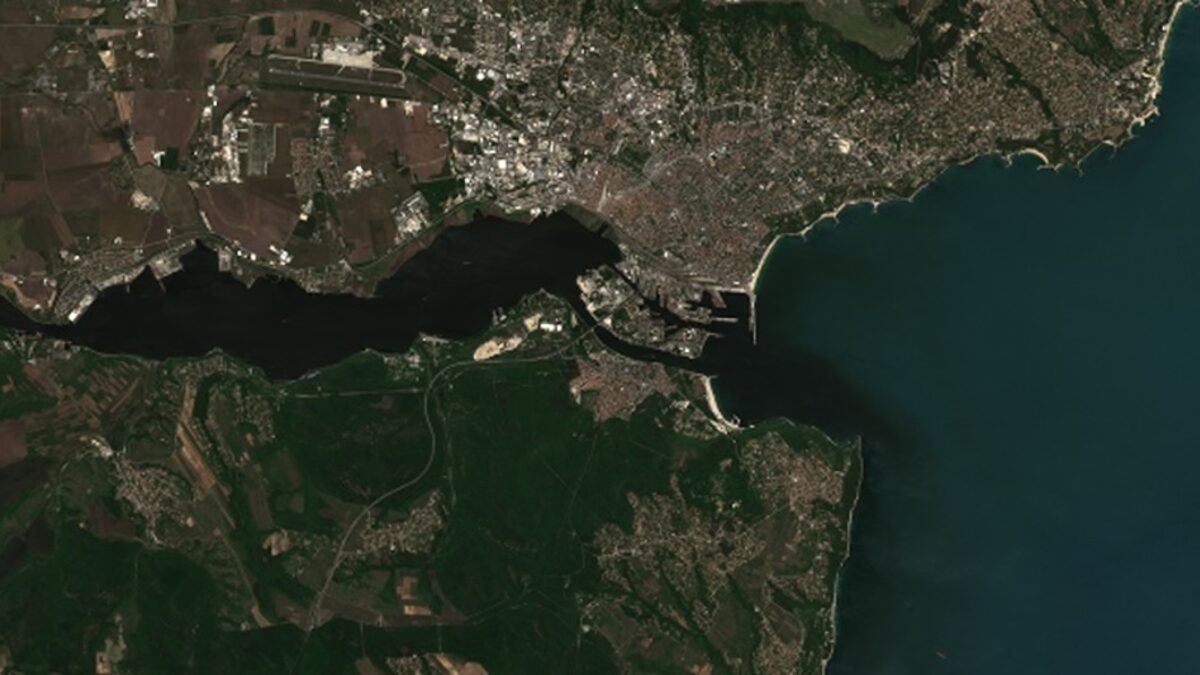 Сателитна снимка на замърсеното с фекални води Варненско езеро, плавателните канали и залива. Кадърът показва как водата, оцветена от водорасли, преждевременно цъфнали заради замърсяването, прониква от езерото в морето.