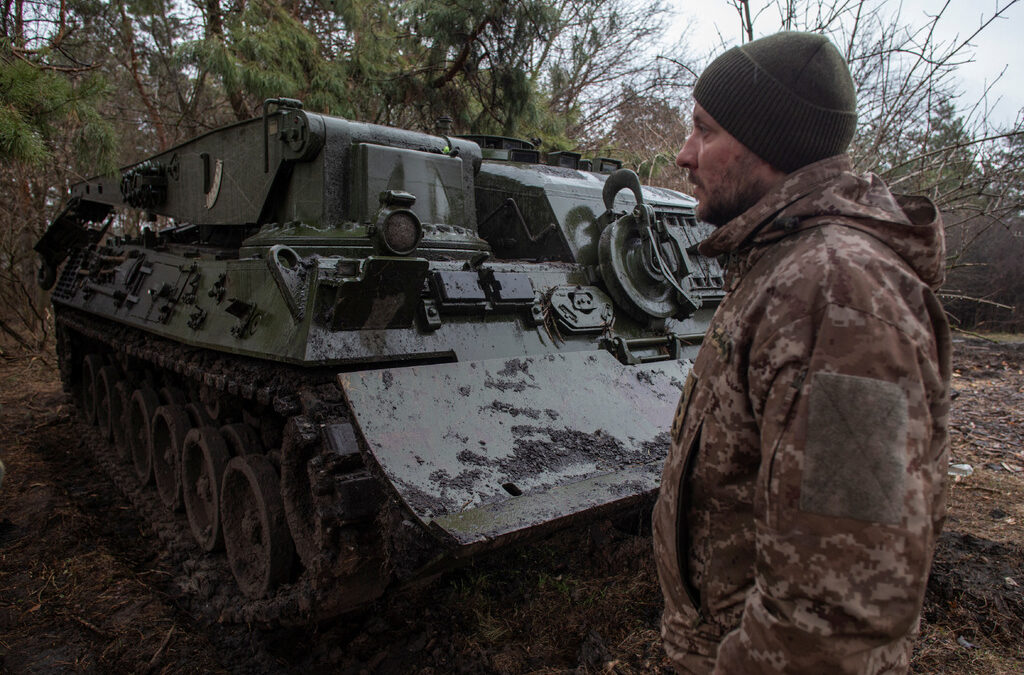Военнослужещ от Първа отделна сиверска танкова бригада стои до германска бронирана евакуационна машина Bergepanzer 2 Военнослужещ от Първа отделна сиверска танкова бригада стои до германска бронирана евакуационна машина Bergepanzer 2