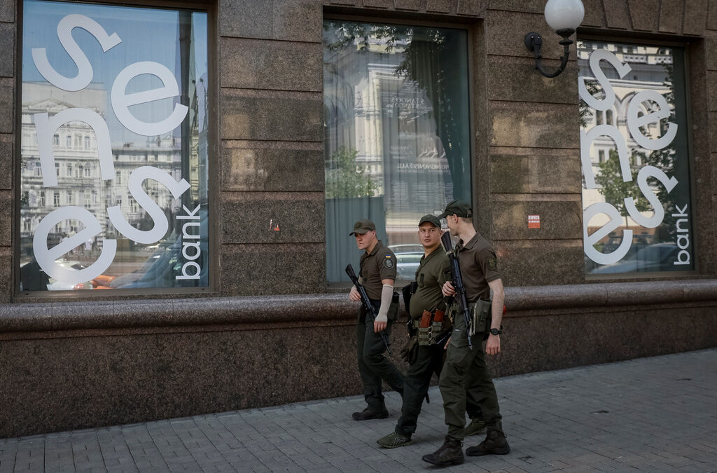 Украински войници минават покрай клон на Sense Bank в центъра на Киев Украински войници минават покрай клон на Sense Bank в центъра на Киев