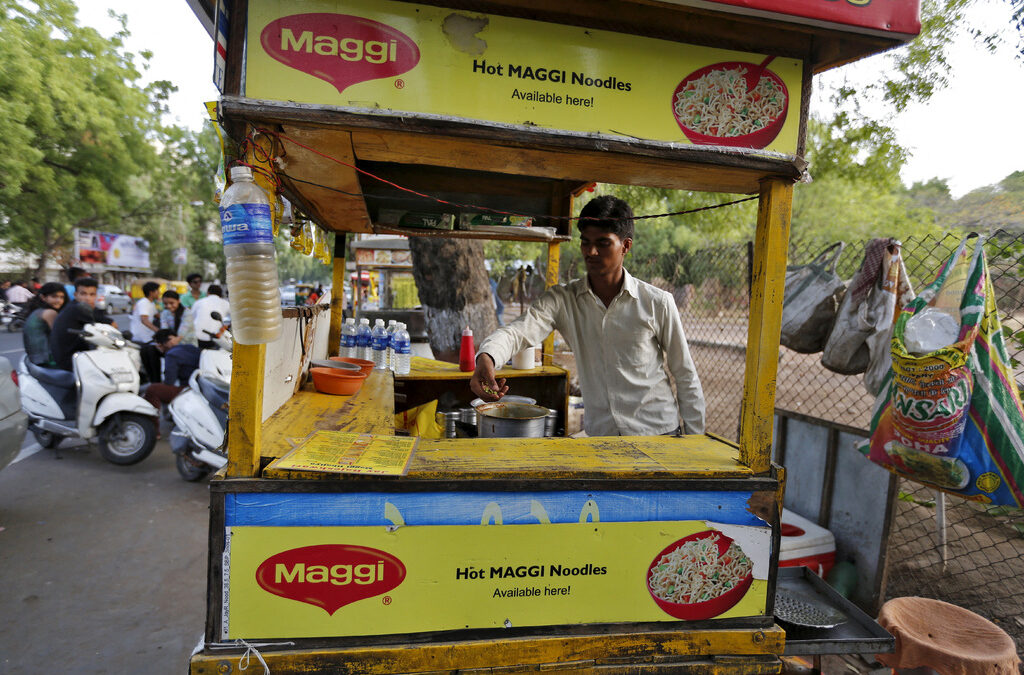 Продавач в крайпътен ресторант за нудъли Maggi в Ахмедабад. Индия, 4 юни 2015 г.