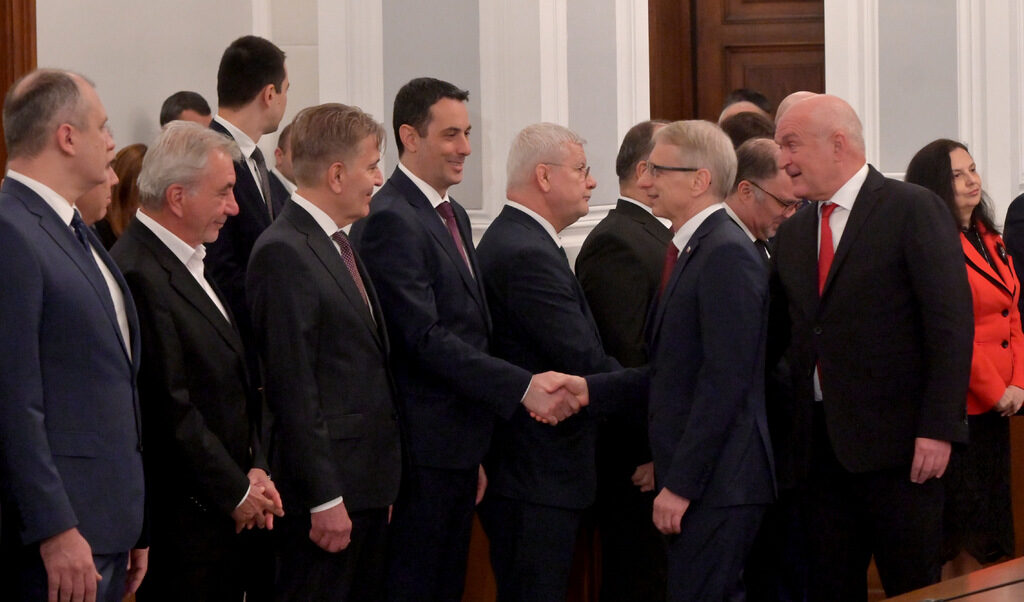 Бившият премиер Николай Денков се здрависва с министъра на транспорта Георги Гвоздейков пред погледа на служебния министър-председател Димитър Главчев при предаването на властта в Министерския съвет.