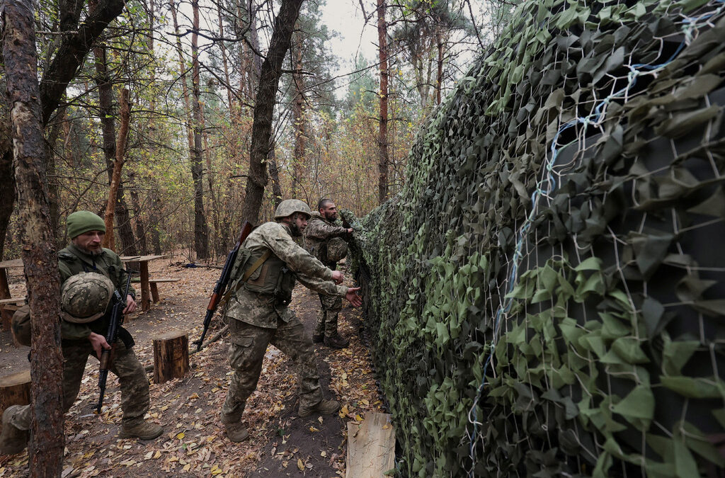 Украински военни прикриват с маскировъчна мрежа самоходна гаубица 2С1 "Гвоздика" на позиция близо до фронтовата линия в Харковска област.