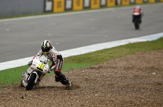 Aprilia 125cc rider Cortese of Germany tries to lift his bike after falling during the Spanish Grand Prix in Jerez