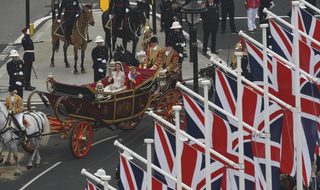 Britain's Prince William and Catherine, Duchess of Cambridge wave as they travel to Buckingham Palace in a 1902 State Landau along the Procession Route after their wedding in London