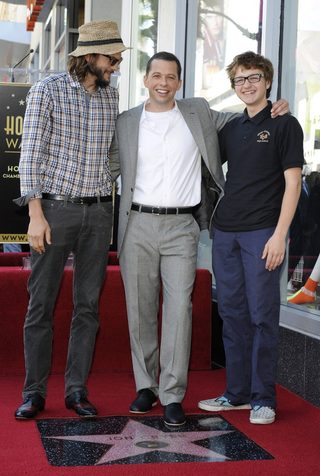 Cryer poses with co-stars Kutcher and Jones during a ceremony honoring Cryer with a star on the Hollywood Walk of Fame in Los Angeles