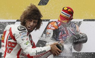 Honda MotoGP rider Stoner of Australia sprays champagne over Honda MotoGP rider Simoncelli of Italy at Phillip Island