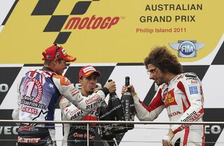 Honda MotoGP riders Stoner of Australia, Simoncelli of Italy and Dovizioso of Italy celebrate on the podium with champagne at Phillip Island