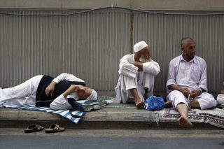 Muslim pilgrim rest by the road after prayers at the Grand Mosque during the annual haj pilgrimage in Mecca