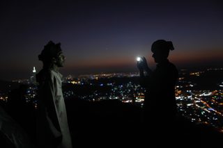 A pilgrim take photos at the top of Mount Al-Noor during the annual haj pilgrimage in Mecca