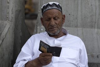 A pilgrim reads the Koran outside the Grand Mosque during the annual haj pilgrimage in Mecca