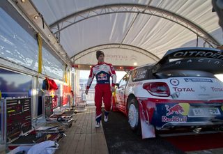 France's Loeb stands beside his Citroen DS3 WRC at the service center during the qualification for the World Rally Championship Rally Sweden in Hagfors