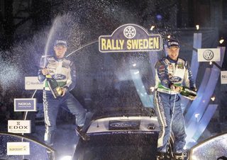 Finland's Latvala and his co-driver Anttila spray champagne as they celebrate winning the WRC Rally of Sweden before the victory ceremony in Karlstad