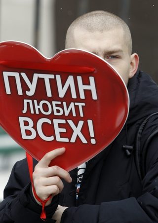 An activist holds a placard during a protest rally called The White Ring in Moscow