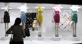 A visitor looks at fashion creations during the press presentation of the 'Louis Vuitton - Marc Jacobs: The Exhibition' at the Museem of Decorative Arts in Paris