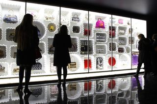 Visitors look at fashion creations during the press presentation of the 'Louis Vuitton - Marc Jacobs: The Exhibition' at the Museem of Decorative Arts in Paris