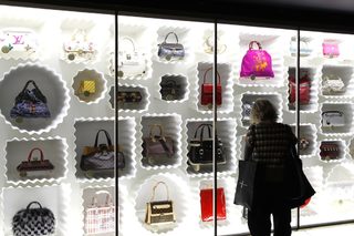 A visitor looks at fashion creations during the press presentation of the 'Louis Vuitton - Marc Jacobs: The Exhibition' at the Museem of Decorative Arts in Paris