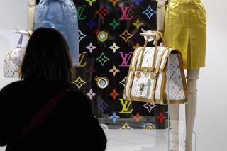 A visitor looks at fashion creations during the press presentation of the 'Louis Vuitton - Marc Jacobs: The Exhibition' at the Museem of Decorative Arts in Paris