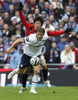 Aston Villa's Petrov shields the ball from Manchester United's Park during their English League Cup final soccer match in London