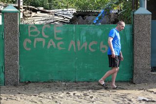 A local resident walks in mud from the floods in the town of Krymsk in Krasnodar region, southern Russia