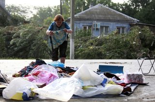 A local resident lays out her belongings on the ground in the town of Krymsk, seriously damaged by floods, in Krasnodar region