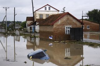 A car lies submerged in a flooded street in the village of Novoukrainsk