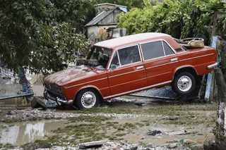 A stranded car is seen in a recently flooded street in the southern Russian town of Krymsk