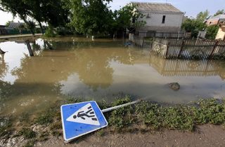 A traffic sign lays on the ground in a flooded street in the town of Krymsk in Krasnodar region