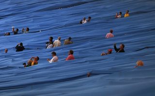 Members of the audience take photographs before the opening ceremony of the London 2012 Olympic Games at the Olympic Stadium