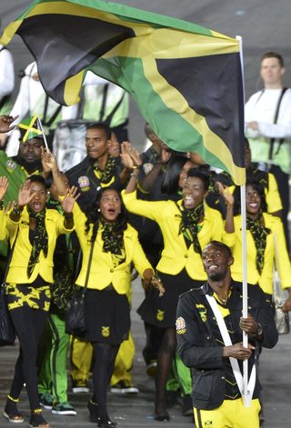 Jamaica's flag bearer Usain Bolt holds the national flag as he leads the contingent in the athletes parade during the opening ceremony of the London 2012 Olympic Games at the Olympic Stadium