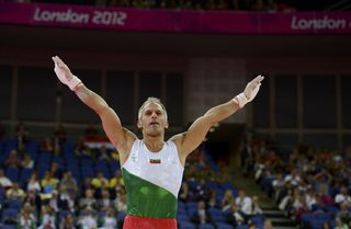 Jordan Jovtchev of Bulgaria gestures as he receives applause from the crowd after competing in the rings in London
