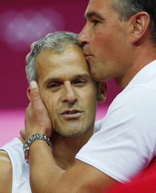 Bulgaria's Jordan Jovtchev is kissed by a coach after competing in the men's gymnastics rings final during the London 2012 Olympic Games