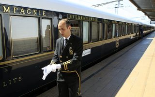 A car attendant puts on his gloves in front of the Orient Express at the main railway station in Bucharest