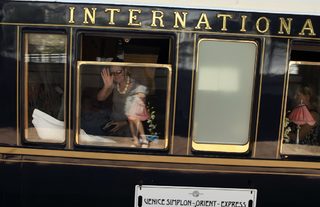 A tourist waves as the Orient Express luxury train arrives at the main railway station in Bucharest