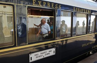 Passengers are reflected in the windows of the Orient Express at the main railway station in Bucharest