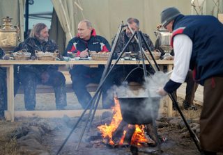 Russian President Vladimir Putin talks with an ornithologist after a flight at Yamalo-Nenets district