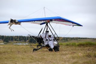 Russian President Vladimir Putin sits in a motorized deltaplane at Yamalo-Nenets district