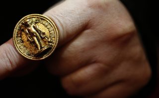 Museum official displays a golden ring, part of a recently unearthed discovery from an ancient Thracian tomb, at the Archaeology Museum in Sofia